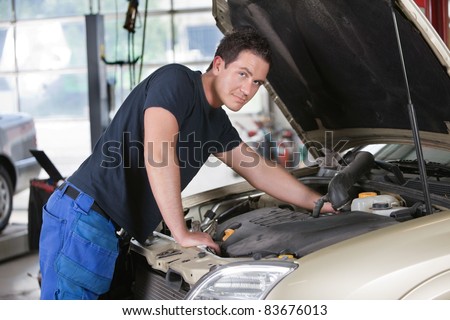 Portrait of a mechanic working on car in garage