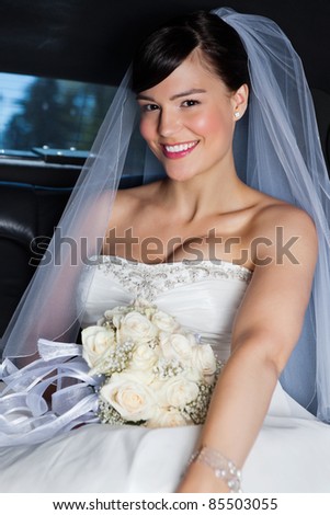 Portrait of happy beautiful bride in limousine