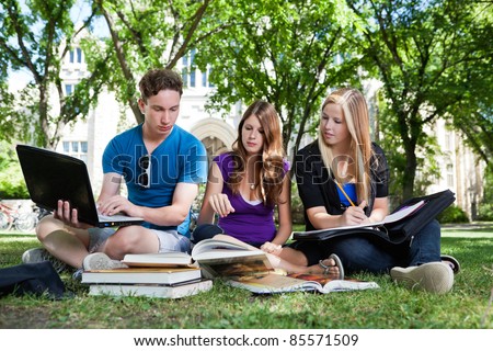 Group of college students studying together on campus ground