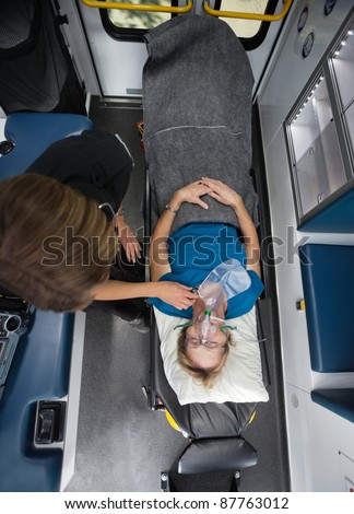 Above view of senior woman in ambulance with EMT worker
