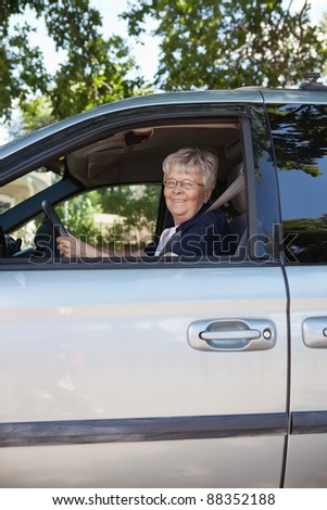 Portrait of pretty senior woman driving car