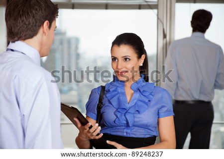 Smiling business woman standing with her colleague in office