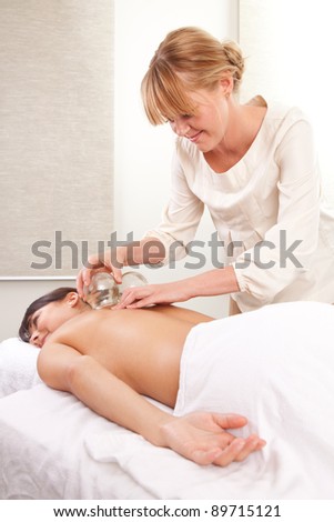 Portrait of an acupuncturist removing a glass globe in a fire cupping therapy session