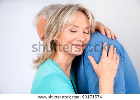 Wife embracing her husband with eyes closed