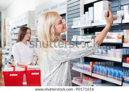Happy woman buying medicine at pharmacy store