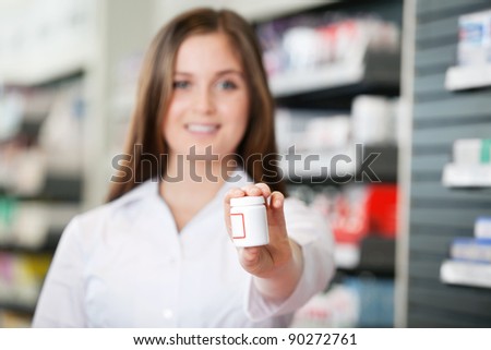Female pharmacist looking at camera recommending medicine