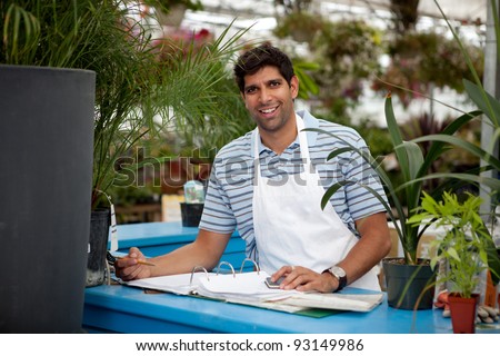 Young male garden center employee at check out counter