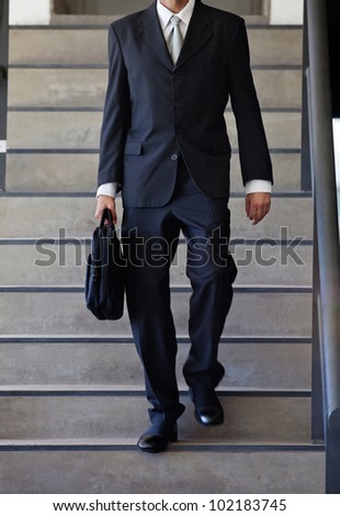 Cropped image of businessman walking down the stairs