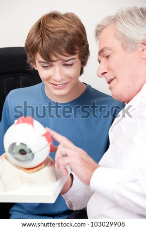 Optometrist showing medical eye model.