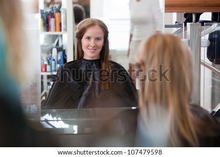 Women looking in mirror at beauty salon.
