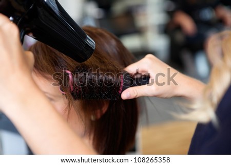 Close up of beautician\'s hand setting the hair properly after haircut