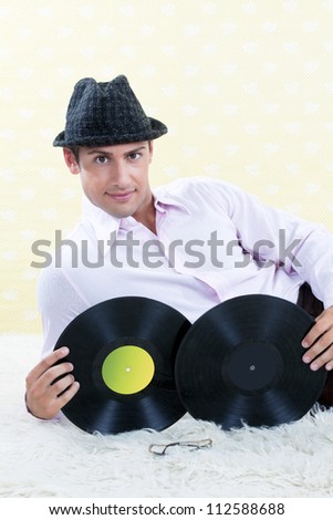 Man posing with vinyl records in studio