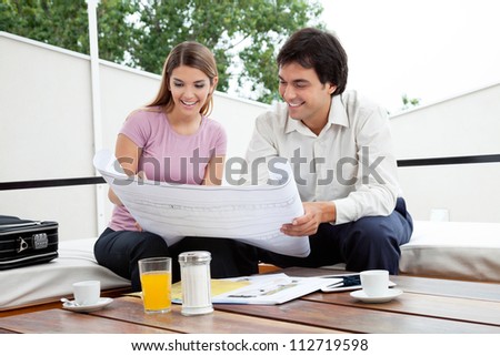 Male architect discussing house plans with female