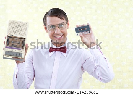 Man holding old audio cassette and player.