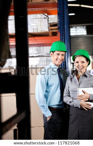 Portrait of two young supervisors with digital tablet smiling together at warehouse