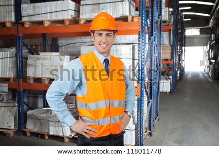 Portrait of confident young supervisor standing at warehouse