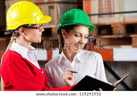 Female supervisor and colleague working together at warehouse