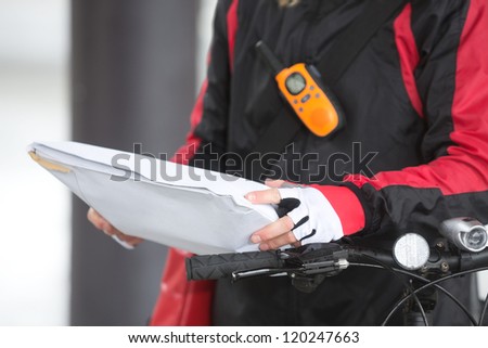 Mid section of female cyclist holding courier package