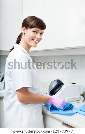 Female Dentist preparing tools for sterilization in an autoclav