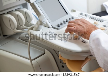 Close up of male hand operating ultrasound machine
