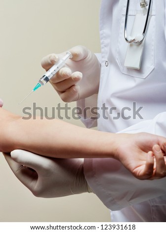 Doctor about to stick needle in patients arm with injection
