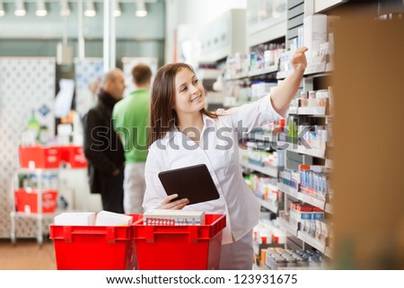 Smiling young woman using a digital tablet for shopping at supermarket