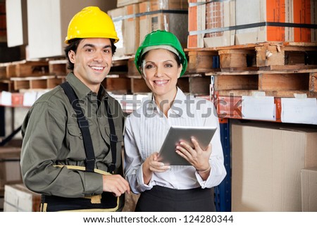 Young female supervisor instructing foreman at warehouse