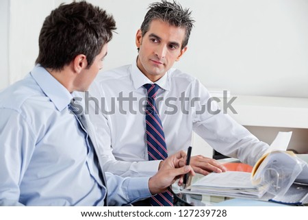 Businessmen discussing paperwork in a meeting at office