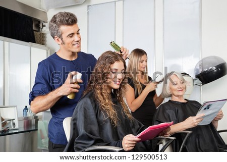Male And Female Hairdressers Setting Up Client\'S Hair In Beauty Salon