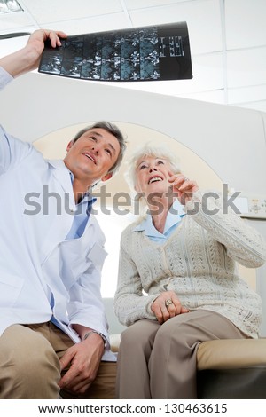 Mature male radiologist and senior female patient looking at x-ray