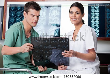 Medical technicians analyzing MRI x-ray of patient at clinic