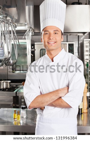 Portrait of young male chef with arms crossed in restaurant kitchen