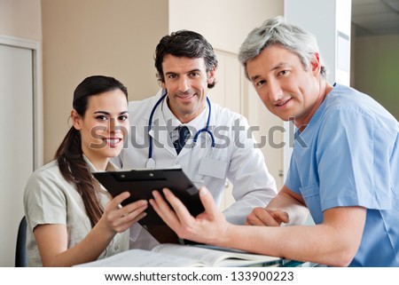 Portrait of multiethnic medical professionals smiling while standing at hospital reception