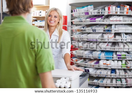 Pharmacist Helping Customer At Counter