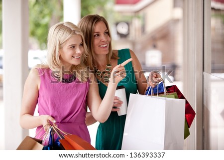 Two Pretty Women Windows Shopping In A Down Town City