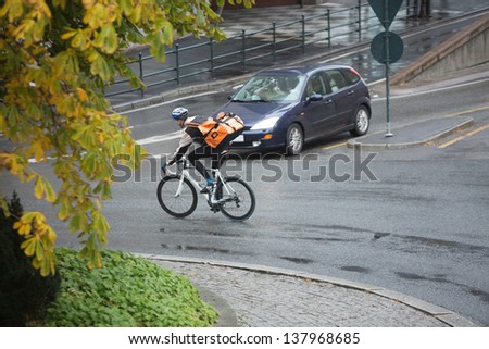 Man in protective gear with backpack riding bicycle on street