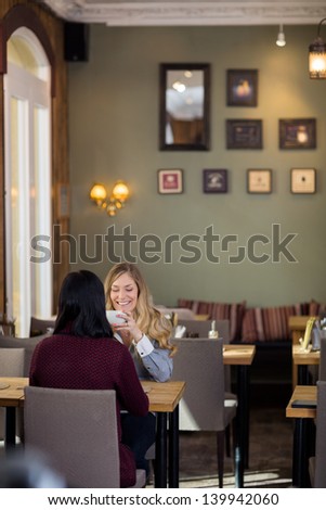 Happy Young Woman Having Coffee With Friend At Coffeeshop