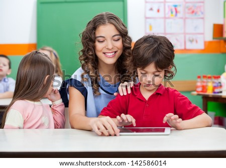 Little boy with teacher using digital tablet in kindergarten Little boy with teacher using digital tablet in kindergarten