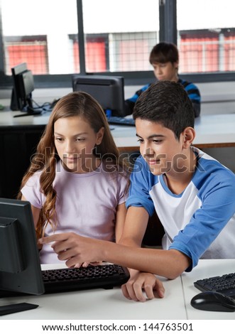 High school students using computer at desk in lab