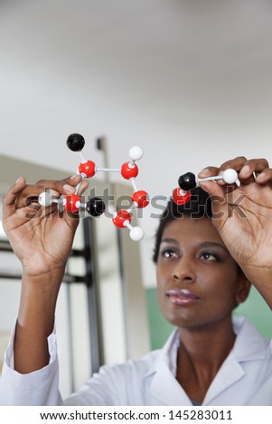 African American young female teacher looking at molecular structure in lab
