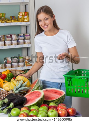 Portrait of beautiful young woman shopping fruits and vegetables in grocery store