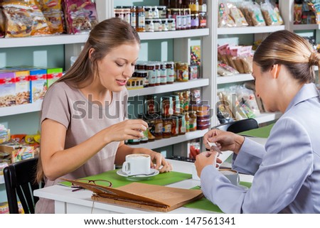 Women having coffee at table in grocery store
