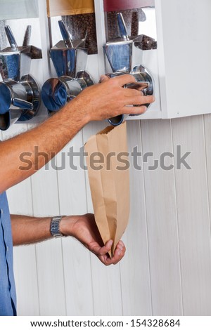 Cropped image of male customer buying coffee beans from vending machine