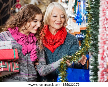 Beautiful Mother And Daughter Buying Christmas Decorations In Store