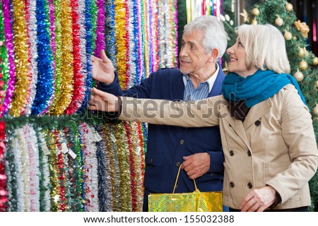 Senior couple shopping for tinsels at Christmas store
