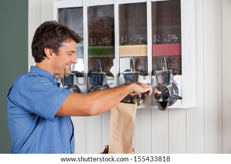 Side view of mid adult man buying coffee from vending machine in supermarket
