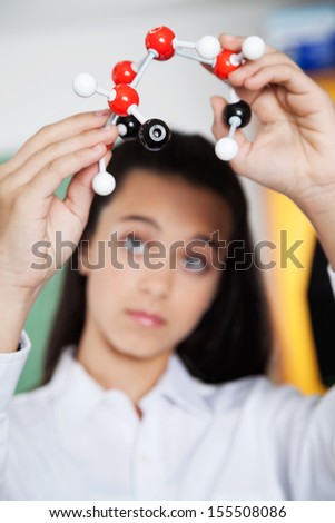 Closeup of female high school student looking at molecular structure in lab