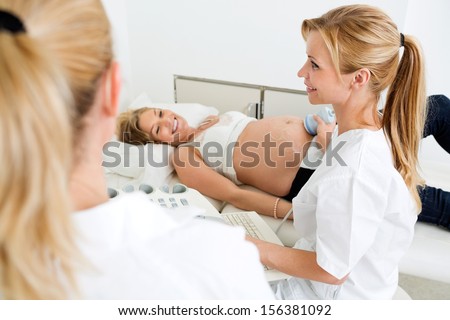 Pregnant woman getting ultrasound examination from obstetricians in clinic