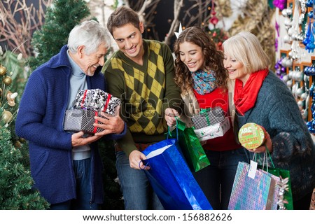 Happy family with shopping bags and presents in Christmas store
