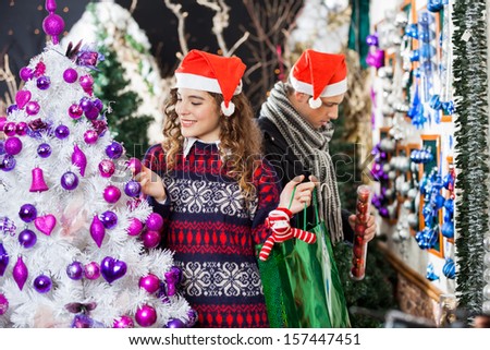 Young couple shopping for Christmas decorations in store
